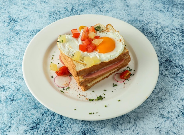 toast hawaïen surmonté d'un œuf et d'une tomate au côté ensoleillé servi dans une assiette isolée en arrière-plan vue supérieure de la nourriture italienne