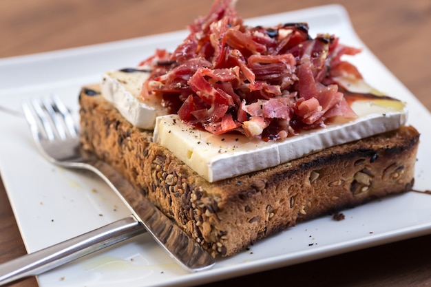 Toast de jambon Serrano, fromage brie et confiture de tomates.