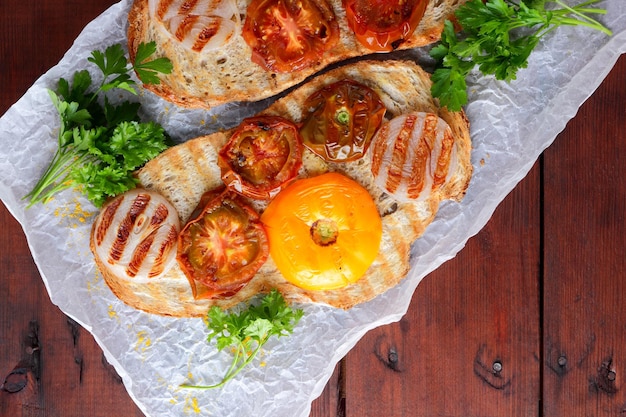 Toast avec des légumes grillés sur fond de bois Sandwich grillé avec des tomates, des oignons et des herbes Toast végétalien avec des légumes et du miel