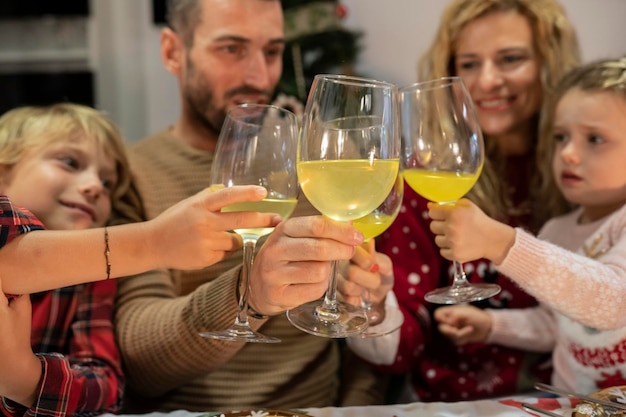 Toast de noël en famille avec jus de se concentrer sur la tasse