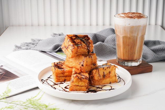 Toast ouest noir et blanc avec thé au lait servi dans un plat isolé sur la vue latérale de la table en bois