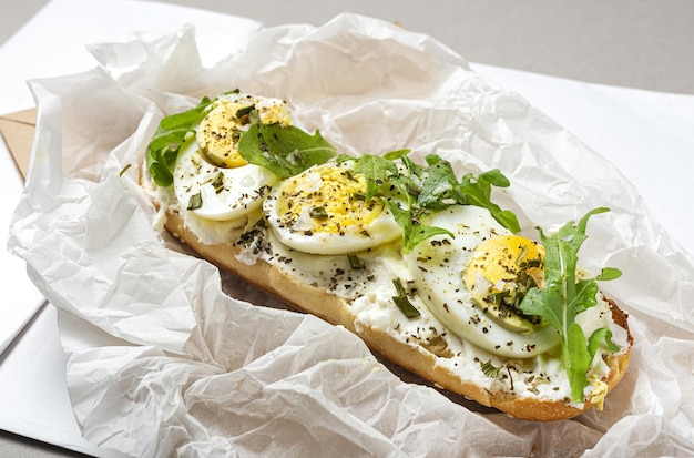 Toast avec salade de roquette au fromage à la crème et œuf à la coque