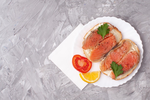 Photo toast sandwichs aux tomates et saumon sur fond de béton