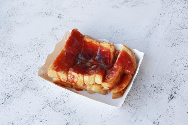 Toast sucré avec confiture de myrtilles dans une boîte en papier sur fond de pierre dessert fait maison