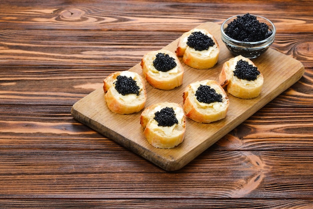 Toasts au caviar noir sur planche à découper