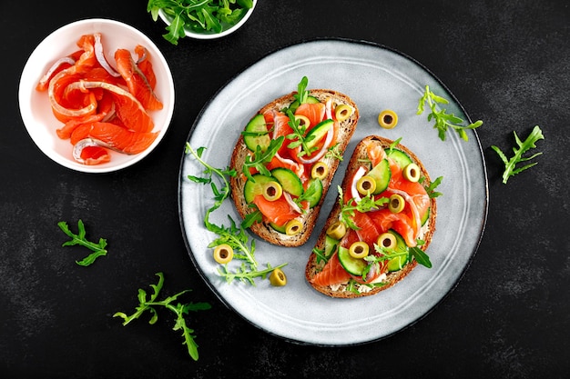 Toasts au saumon salé roquette olives vertes et concombre vue de haut en bas