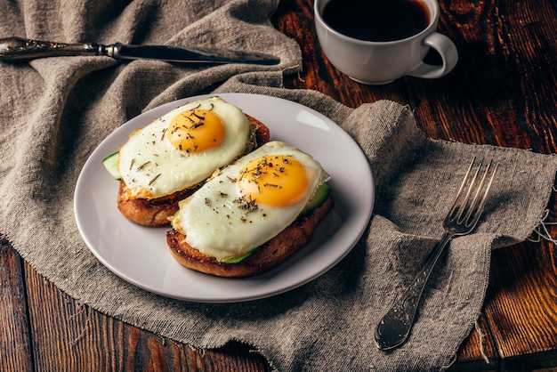 Toasts aux légumes et œufs au plat avec une tasse de café