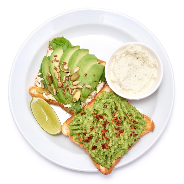 Toasts à l'avocat et au fromage à la crème sur une assiette isolée sur fond blanc