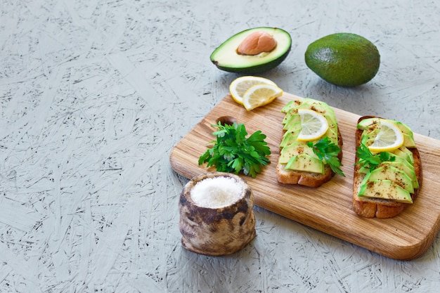 Toasts à l&#39;avocat, citron, piment ou paprika sur fond gris