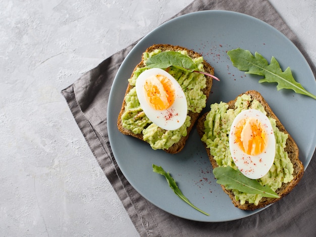 Toasts à l'avocat avec œufs et salade au petit-déjeuner, nourriture propre