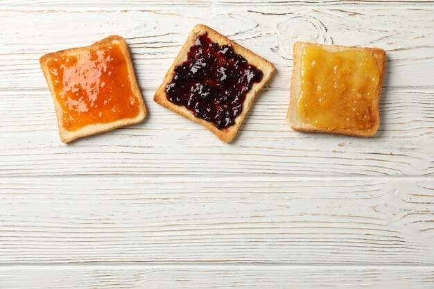 Toasts avec de délicieuses confitures sur fond de bois, vue de dessus