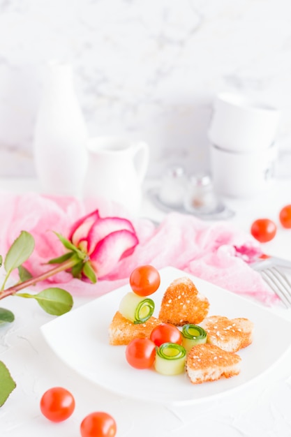 Toasts en forme de coeur et légumes sur une assiette