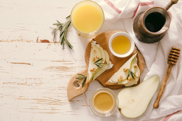 Toasts avec poire, fromage de chèvre et noix, miel, romarin