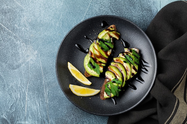 Toasts de seigle épicé avec avocat et citron et sauce balsamique