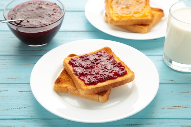 Toasts sucrés avec de la confiture pour le petit déjeuner sur bleu. Vue de dessus