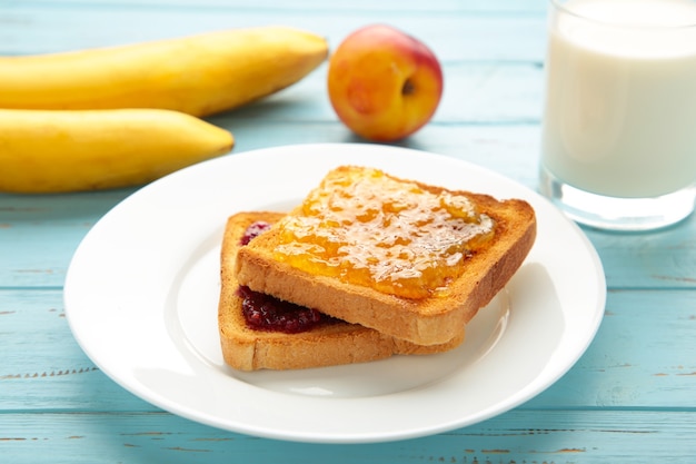 Toasts sucrés avec de la confiture pour le petit déjeuner sur bleu. Vue de dessus