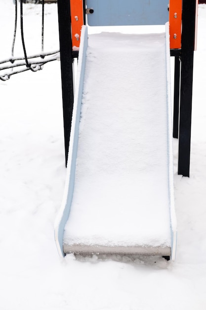 Toboggan vide recouvert de neige dans la rue sur l'aire de jeux