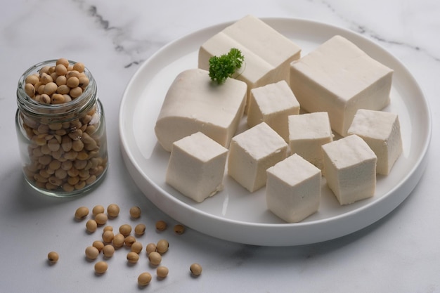 Le tofu ou caillé de haricots est un aliment traditionnel à base de soja. tofu tranché sur un récipient tissé en bambou. Tah