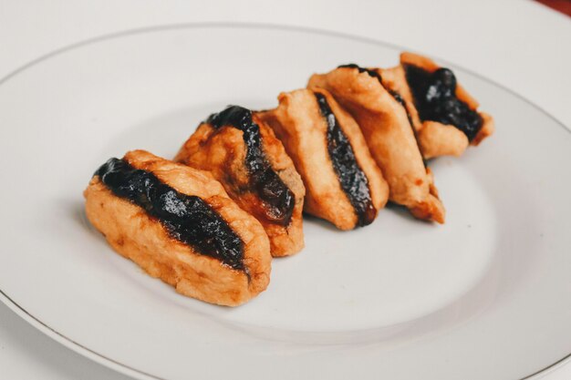 Tofu frit ou tahu avec sauce petis dans une assiette blanche snack indonésien traditionnel javanais