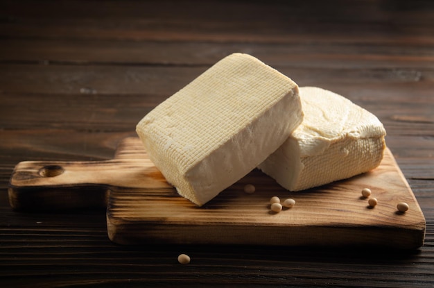 Tofu de soja caillé de légumes sur une planche à découper sur la table de la cuisine