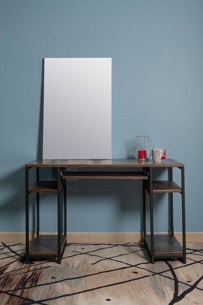 Toile blanche à peindre sur une table en bois contre un mur bleu dans le mocap intérieur