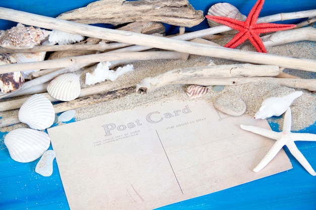 Étoile de mer, bois patiné, coraux et coquillages sur mur en bois bleu se bouchent avec copie papier espace carte postale