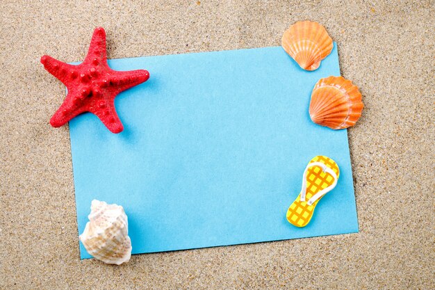 Étoile de mer, cailloux et coquillages gisant sur le sable de la carte postale.