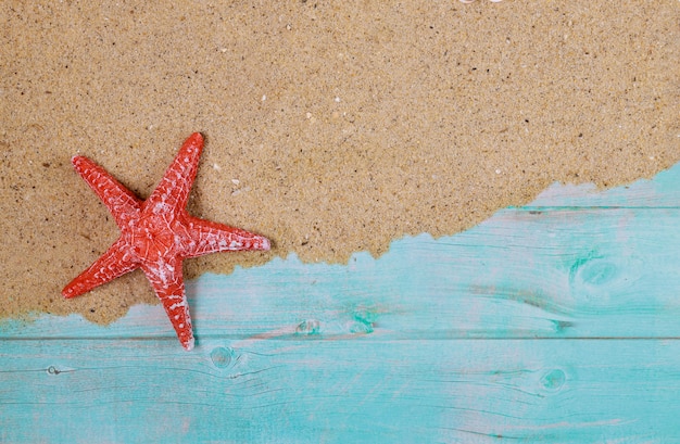 Étoile de mer rouge sur le sable de la mer sur une table en bois bleue