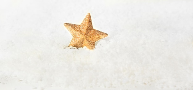 Étoile d'or de jouet d'arbre de Noël sur un fond neigeux Copiez l'espace bokeh