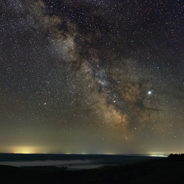 Étoiles dans le ciel la nuit. Voie lactée lumineuse à l'horizon avec du brouillard. Photographié avec une longue exposition.