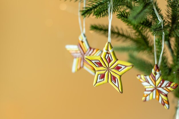 Étoiles de Noël en céramique sur des branches de sapin sur fond beige