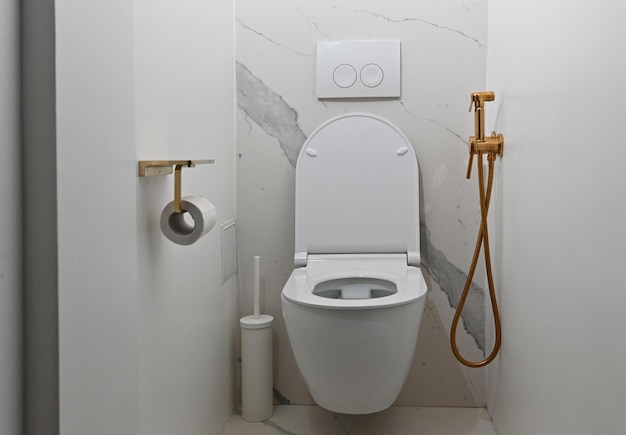 Toilette dans une salle de bain moderne Toilette moderne avec accessoires en or