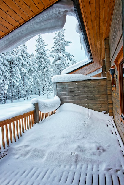 Le toit du chalet est plein de neige et de glaçons à Ruka en Finlande dans le cercle polaire arctique en hiver