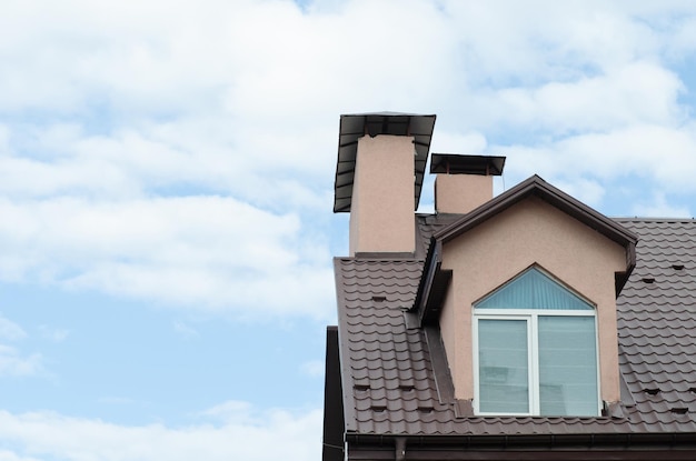 Le toit d'une maison avec un grenier contre le ciel bleu