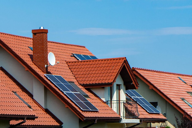 Toit de maison avec modules photovoltaïques. Ferme historique avec panneaux solaires modernes sur le toit et le mur