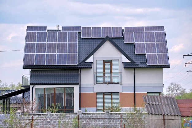 Toit de la maison privée recouvert de panneaux solaires photovoltaïques pour la production d'énergie électrique écologique propre dans la zone urbaine rurale de banlieue Concept de maison autonome