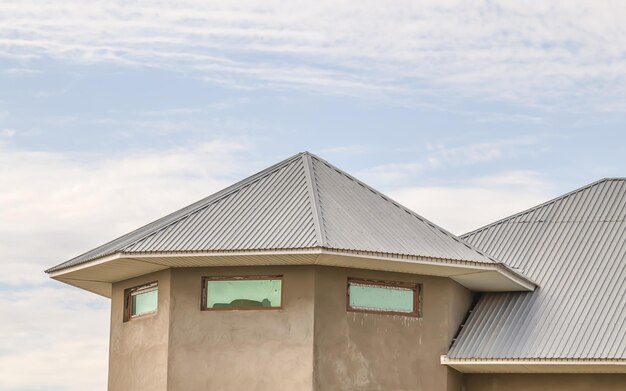 Le toit de la maison d'un profil galvanisé contre le ciel