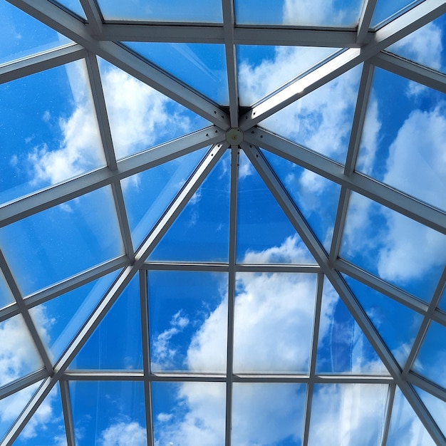 Toit en verre d'un immeuble de bureaux moderne contre un ciel bleu avec des nuages