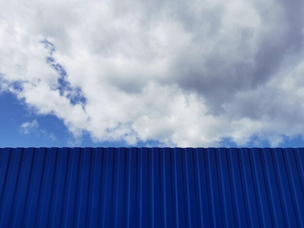 Photo tôle métallique ou ondulée pour murs de toit, bâtiments d'usine et fond bleu