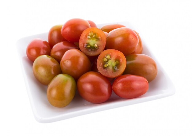 Tomate en assiette blanche sur fond blanc