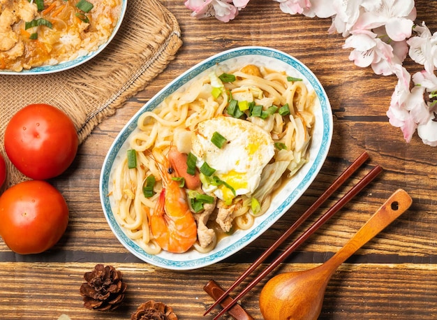 Avec tomate et baguettes servies dans un plat sur une table en bois vue de dessus de la nourriture chinoise