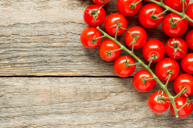 Tomate cerise sur une branche sur un fond d&#39;espace de copie rustique en bois