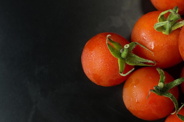 Photo tomate fraîche en gros sur fond de table noire