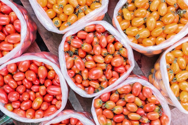 tomate jaune et rouge dans un sac en plastique