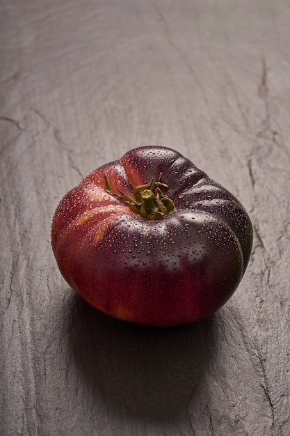 Photo tomate mûre sur ardoise noire