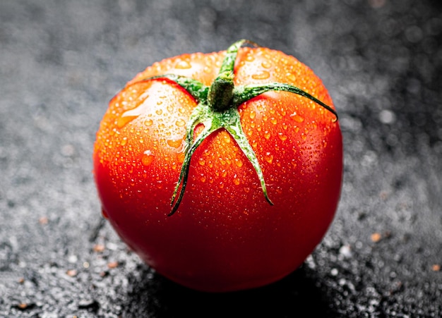 Photo une tomate mûre avec des gouttes d'eau