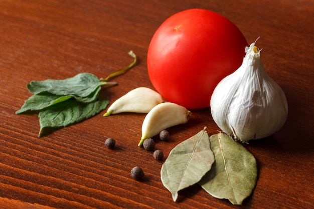 La tomate rouge et l&#39;ail avec des épices sont sur la table.