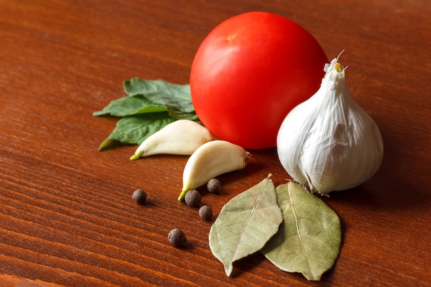 La tomate rouge et l&#39;ail avec des épices sont sur la table.