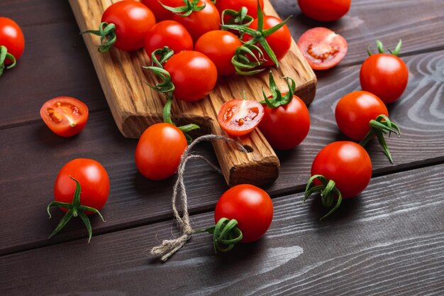 Tomate rouge dans un bol en verre sur une planche à découper sur une table en bois Aliments sains biologiques Ingrédients de cuisine