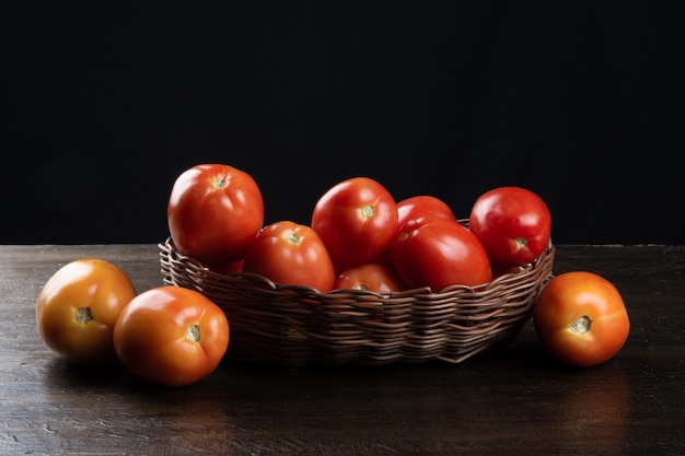 Tomate rouge dans un panier avec table noire.